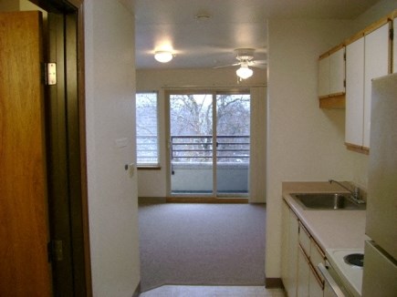 an empty kitchen with a view of a living room