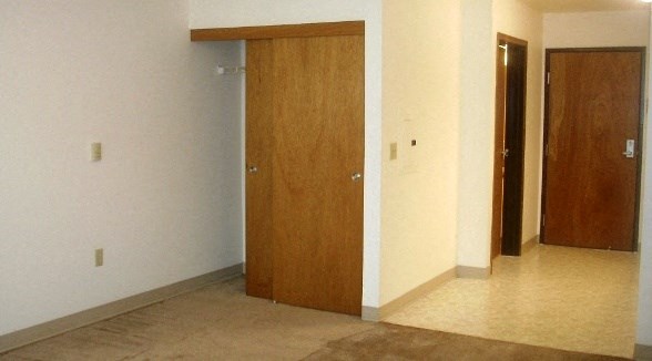 an empty living room with three doors in it