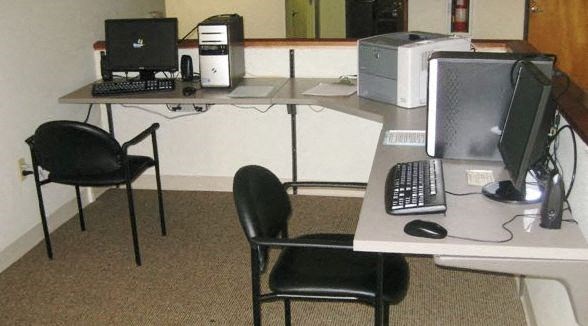 a desk with two chairs and a computer on it