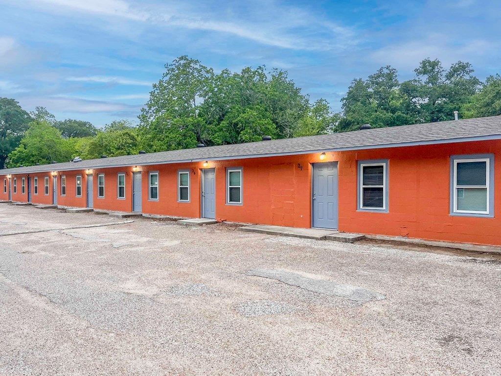 a large orange building with a parking lot in front of it