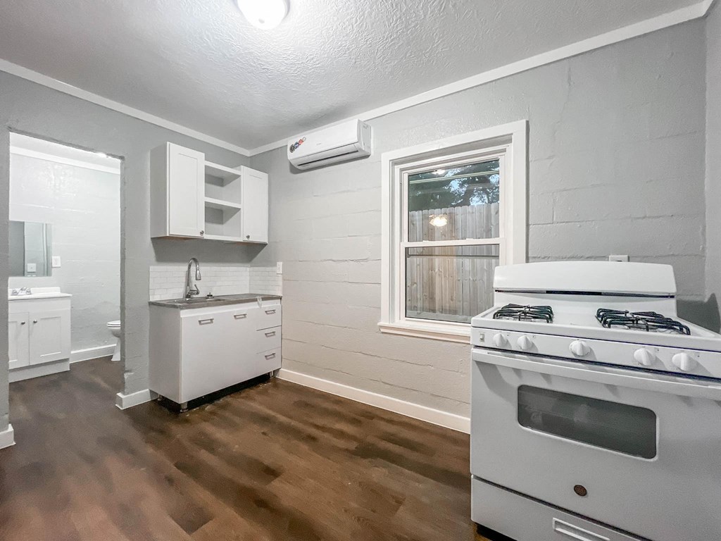 an empty kitchen with a stove and a window