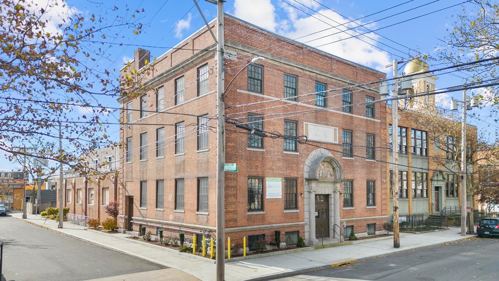 a brick building with an arched doorway on a street