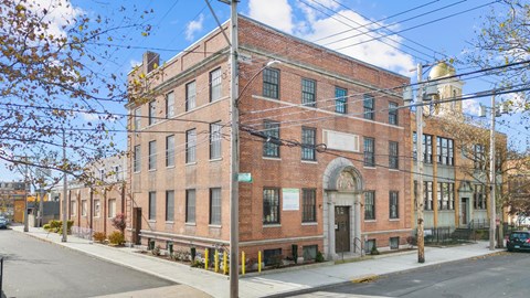 a brick building with an arched doorway on a street
