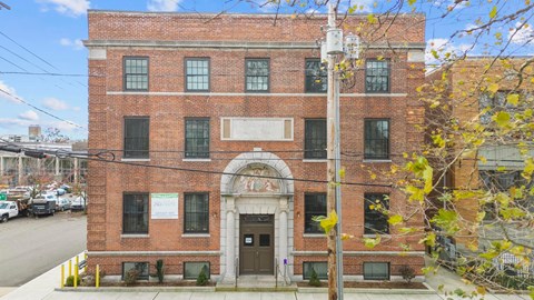 the front of a brick building with a brown door