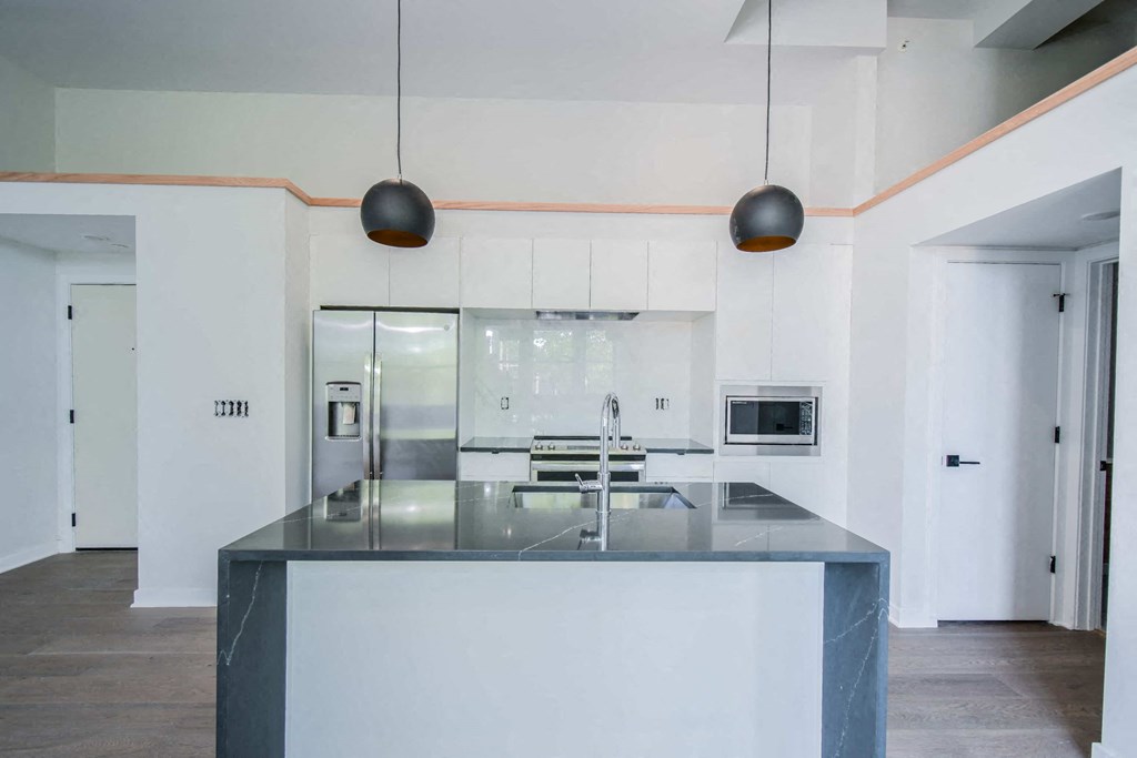 a kitchen with white cabinets and a black counter top