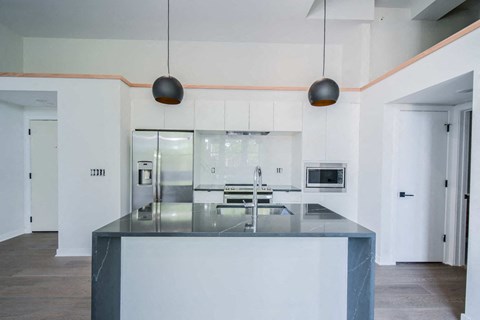 a kitchen with white cabinets and a black counter top