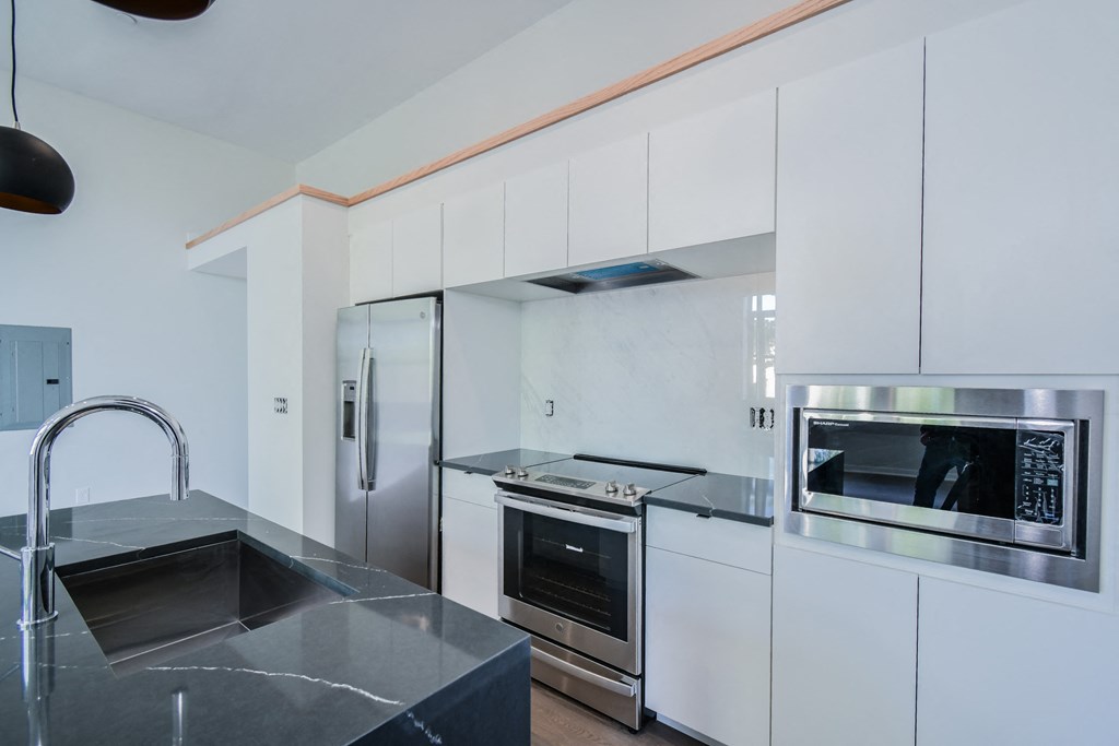 a modern kitchen with white cabinets and stainless steel appliances