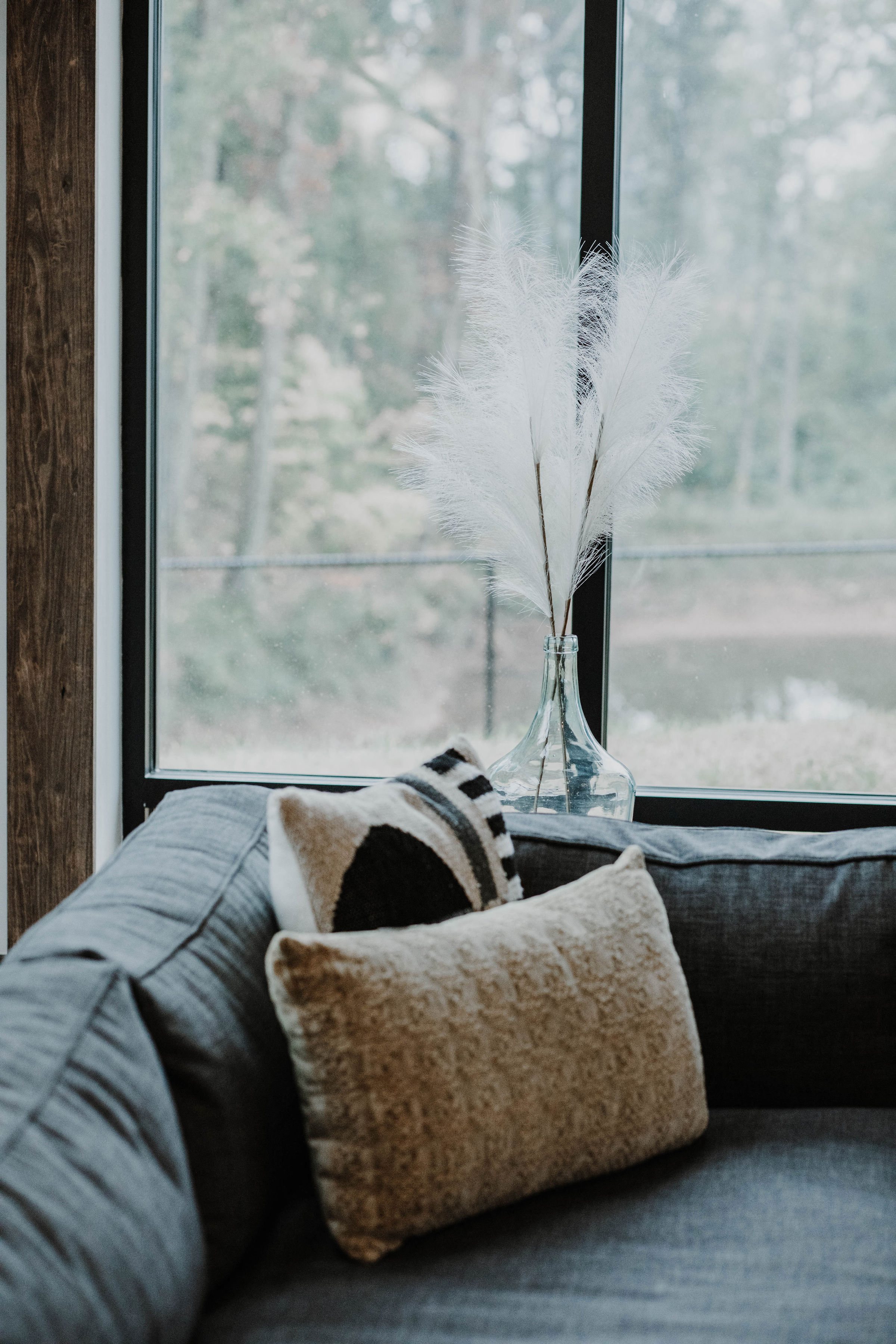 a couch with pillows in front of a window