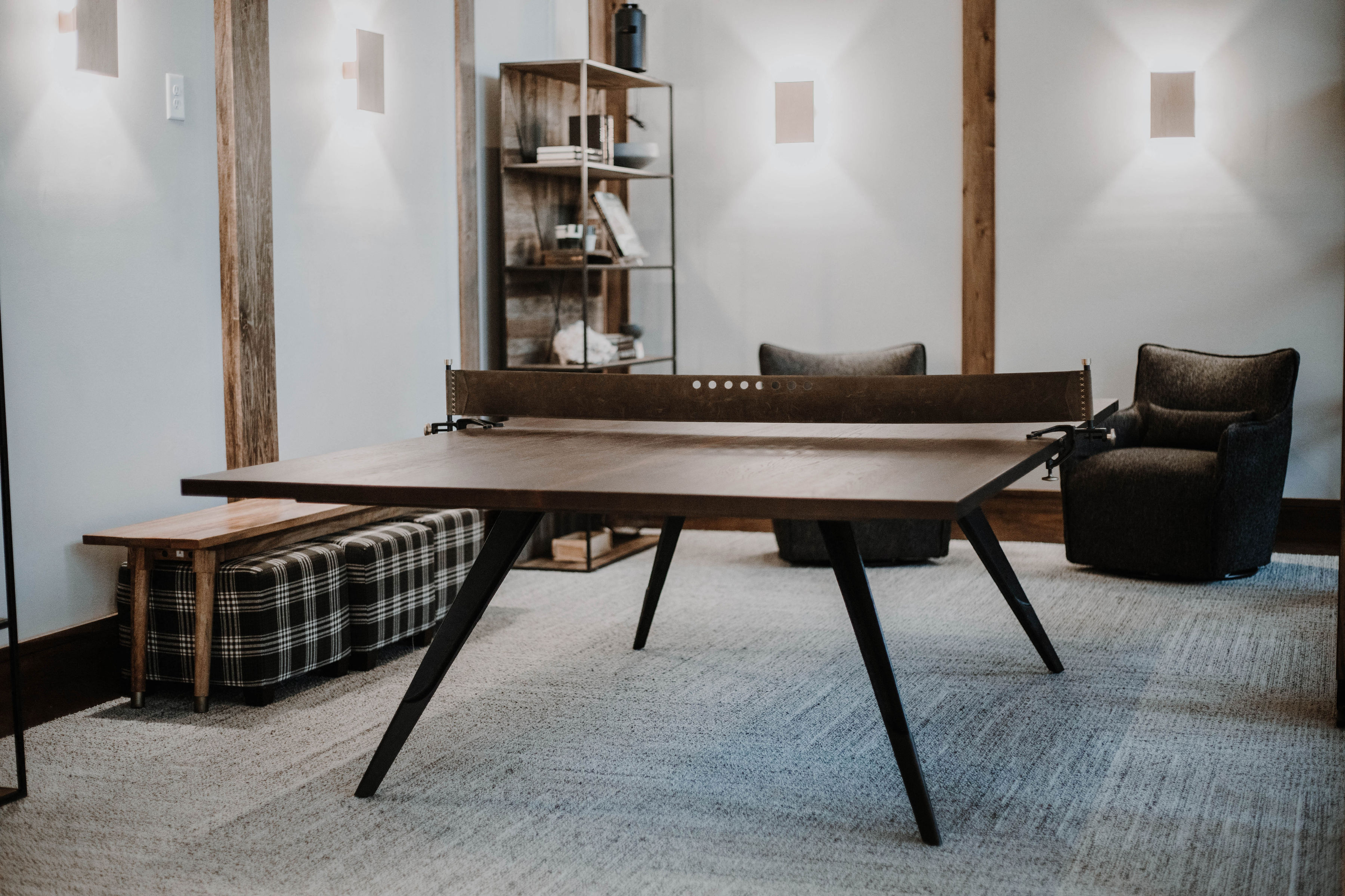 a living room with a ping pong table and chairs