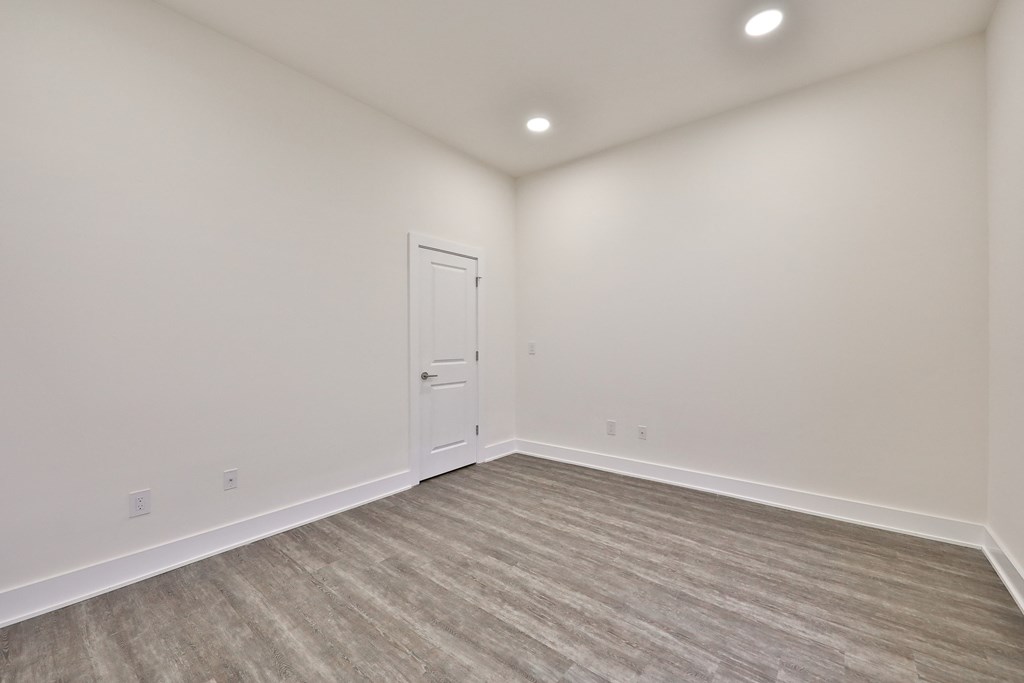 an empty living room with white walls and a white door