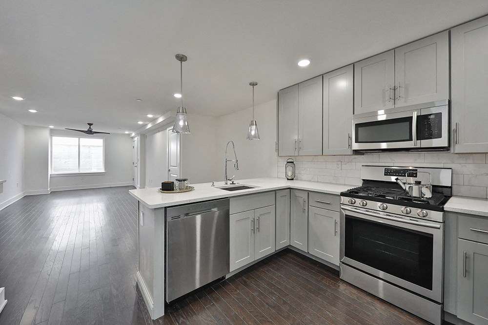a kitchen with white cabinets and stainless steel appliances