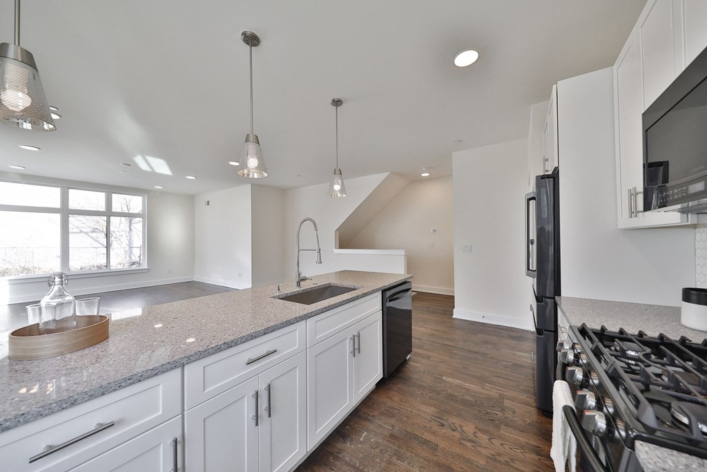 an open kitchen with white cabinets and a large counter top
