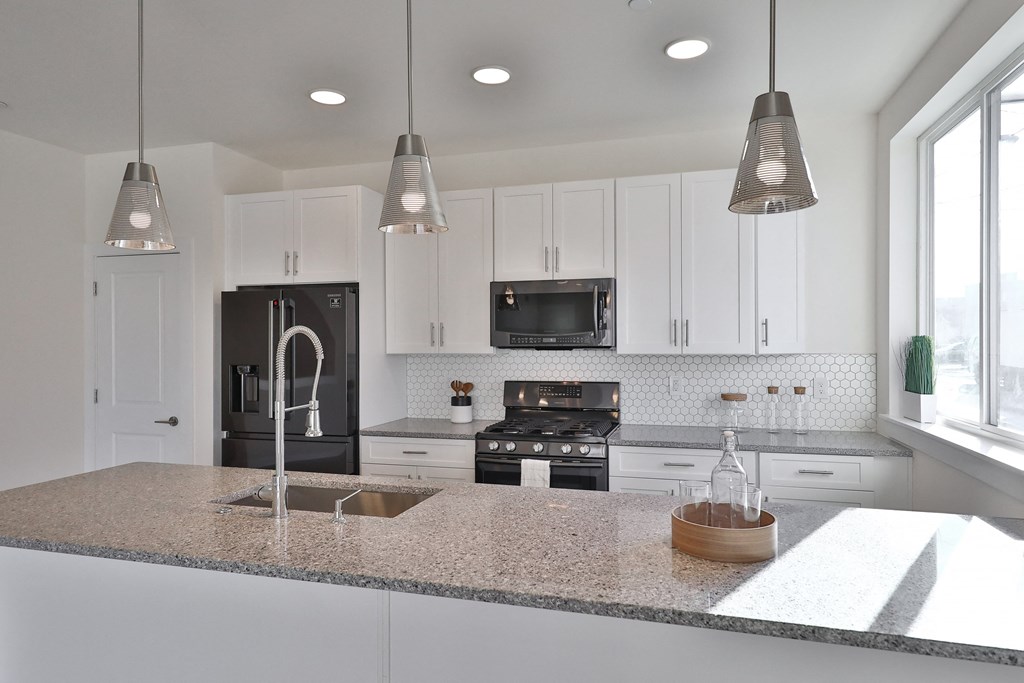 a kitchen with white cabinets and a granite counter top