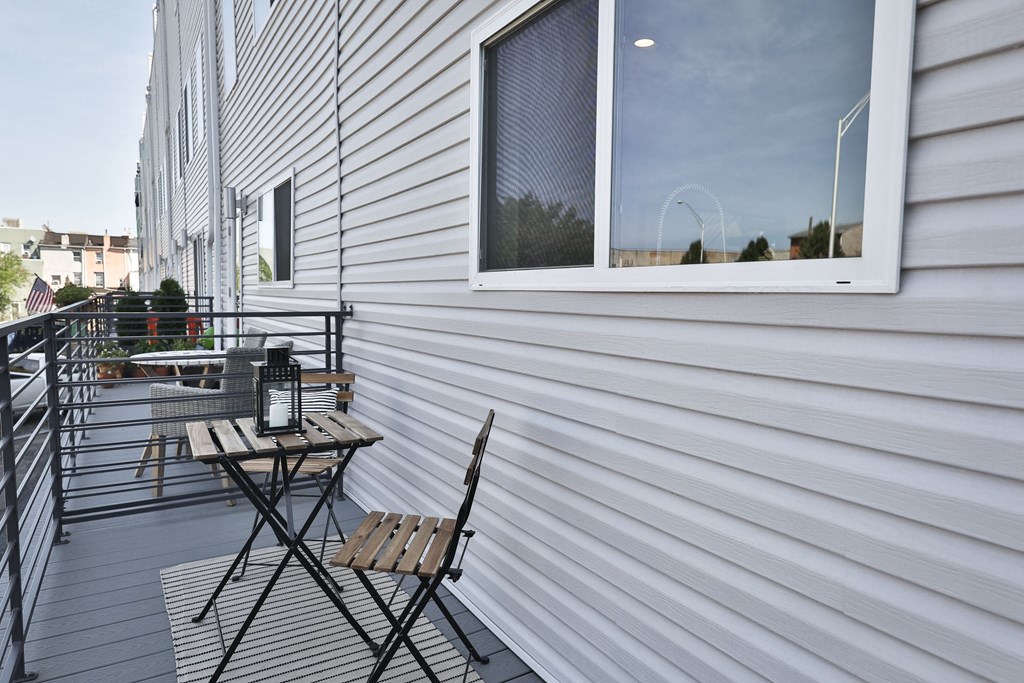 a balcony with two chairs and a table and a window