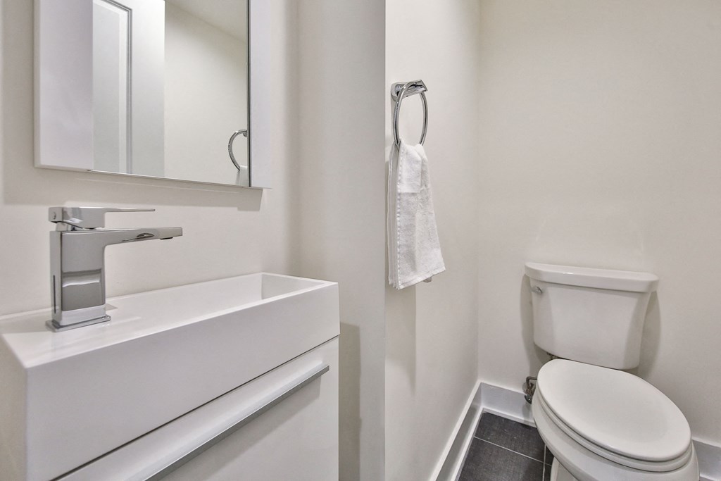 a bathroom with a toilet and a sink and a mirror