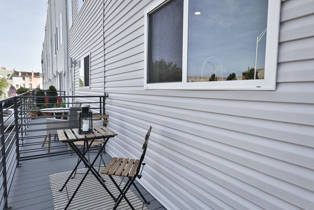 a balcony with two chairs and a table and a window