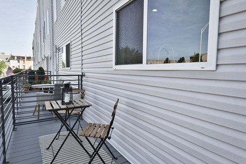 a balcony with two chairs and a table and a window