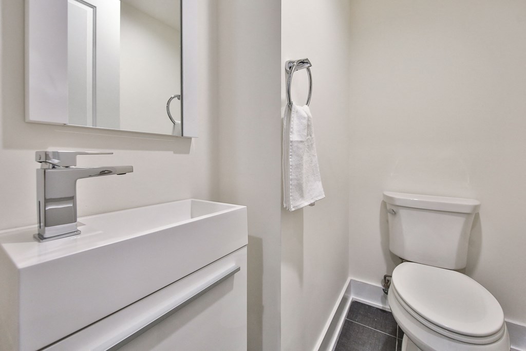 a bathroom with a toilet and a sink and a mirror