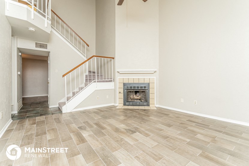 a living room with a fireplace and a staircase