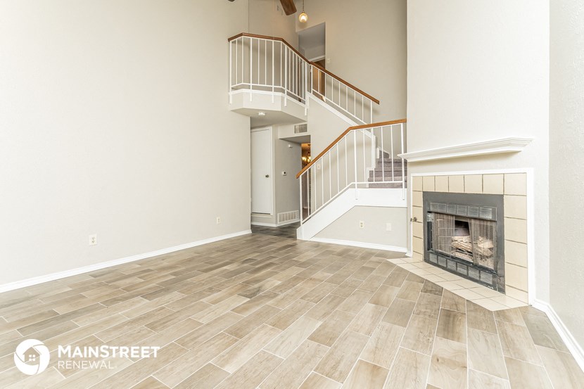 an empty living room with a fireplace and a staircase