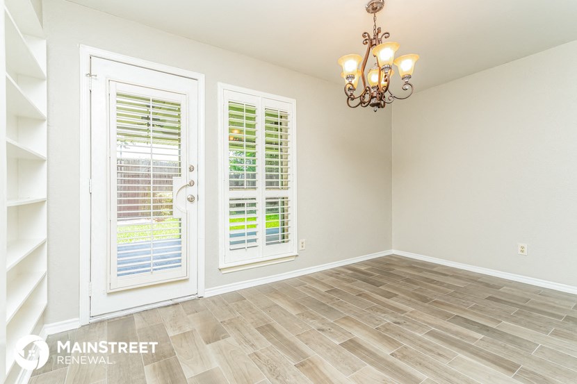 the living room of a new home with a large window and a chandelier