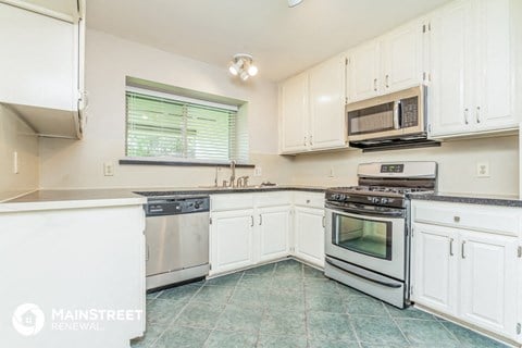 a kitchen with white cabinets and stainless steel appliances