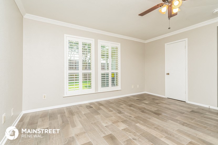 the living room of a new home with wood floors and a ceiling fan