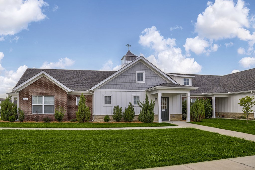 a house with a lawn and a sidewalk in front of it