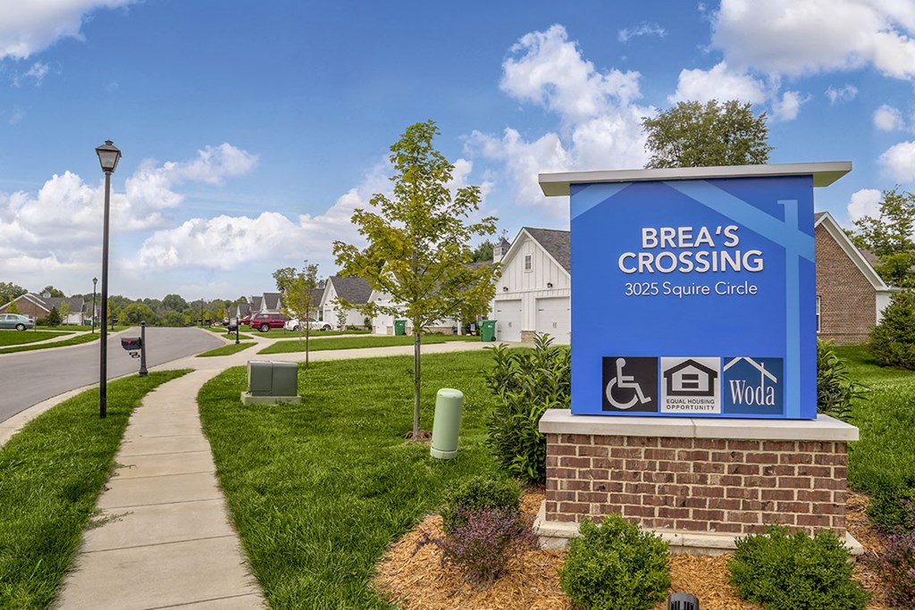 a sign that reads breaks crossing 360 square circle   in front of a sidewalk