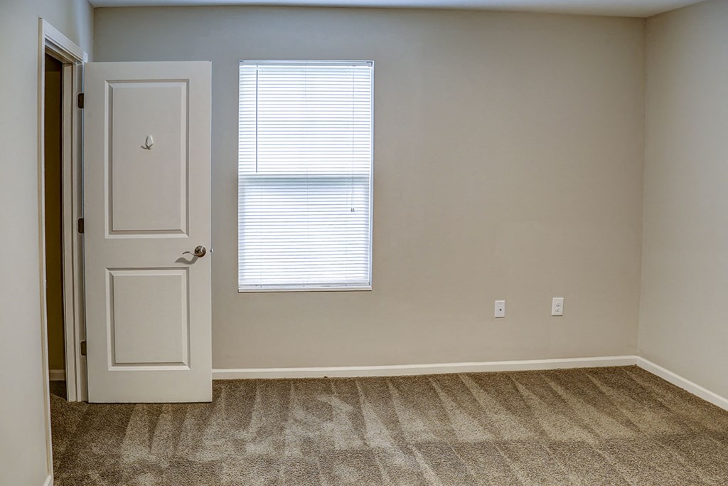 an empty room with a door and a window