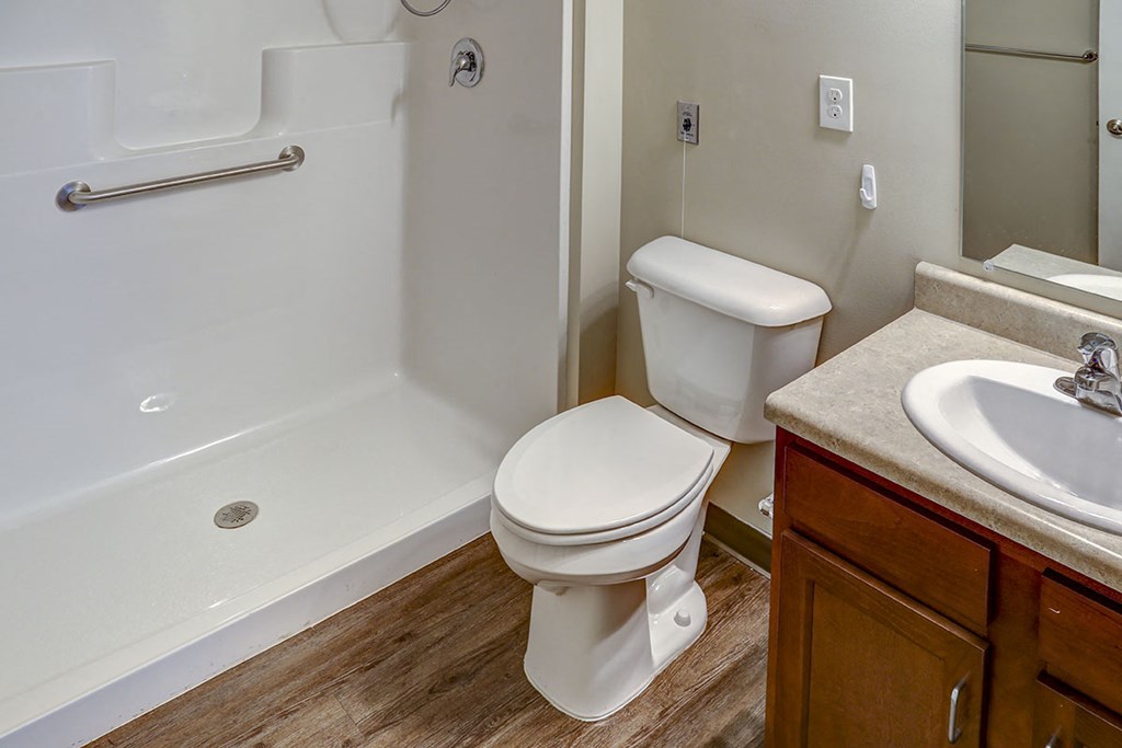 a bathroom with a toilet and a shower and a sink