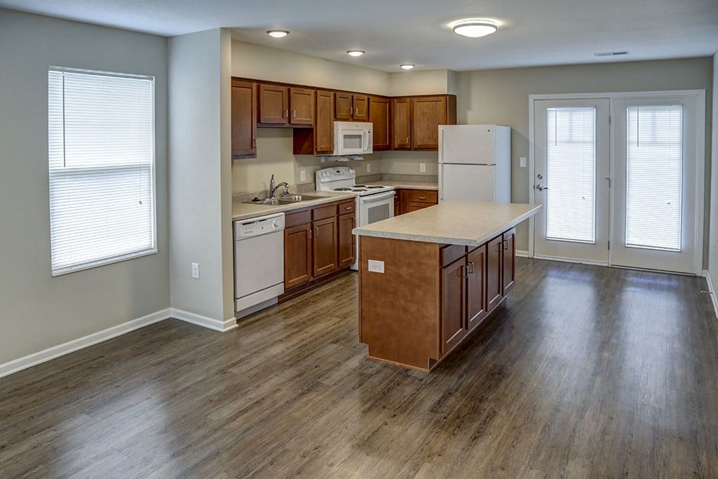 a kitchen with wooden floors and a white refrigerator
