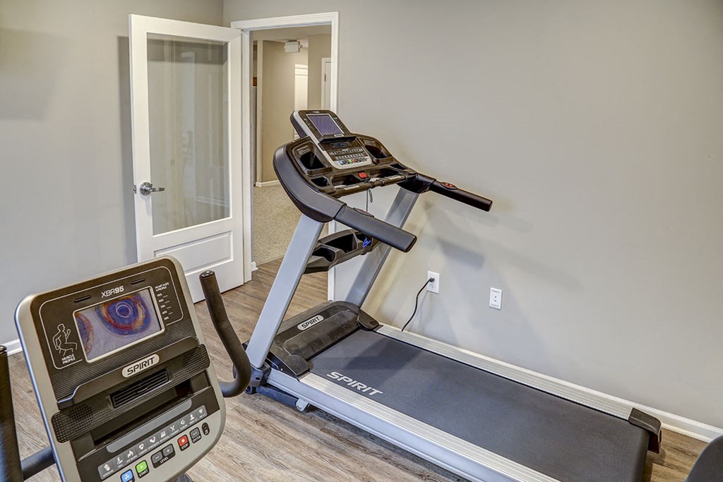 a home gym with a treadmill and a door