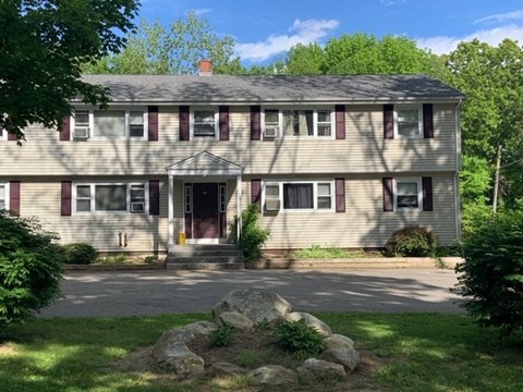 a house with a gravel driveway and trees in the