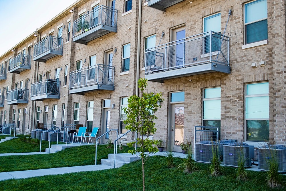 A tree is in front of a building with balconies.