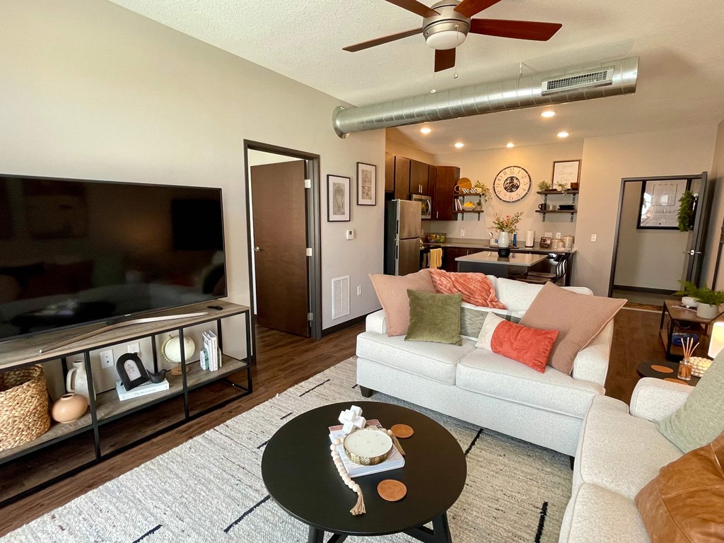 A living room with a white couch and a coffee table with a cake on it.