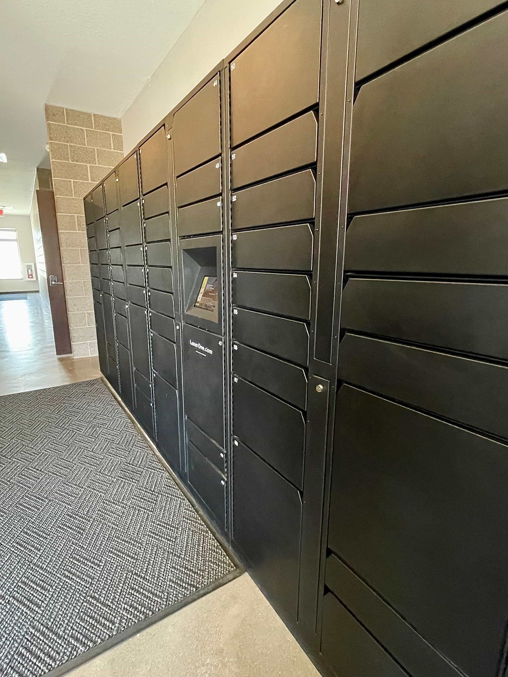 A row of black mailboxes are lined up on the side of a building.