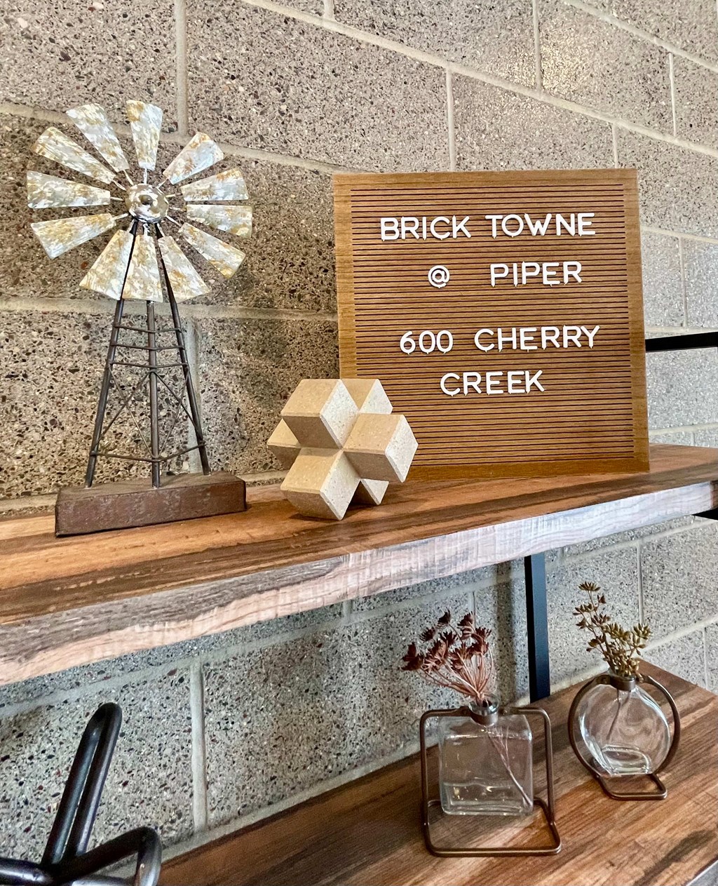 A sign that says Brick Towne Piper 600 Cherry Creek is on a shelf.