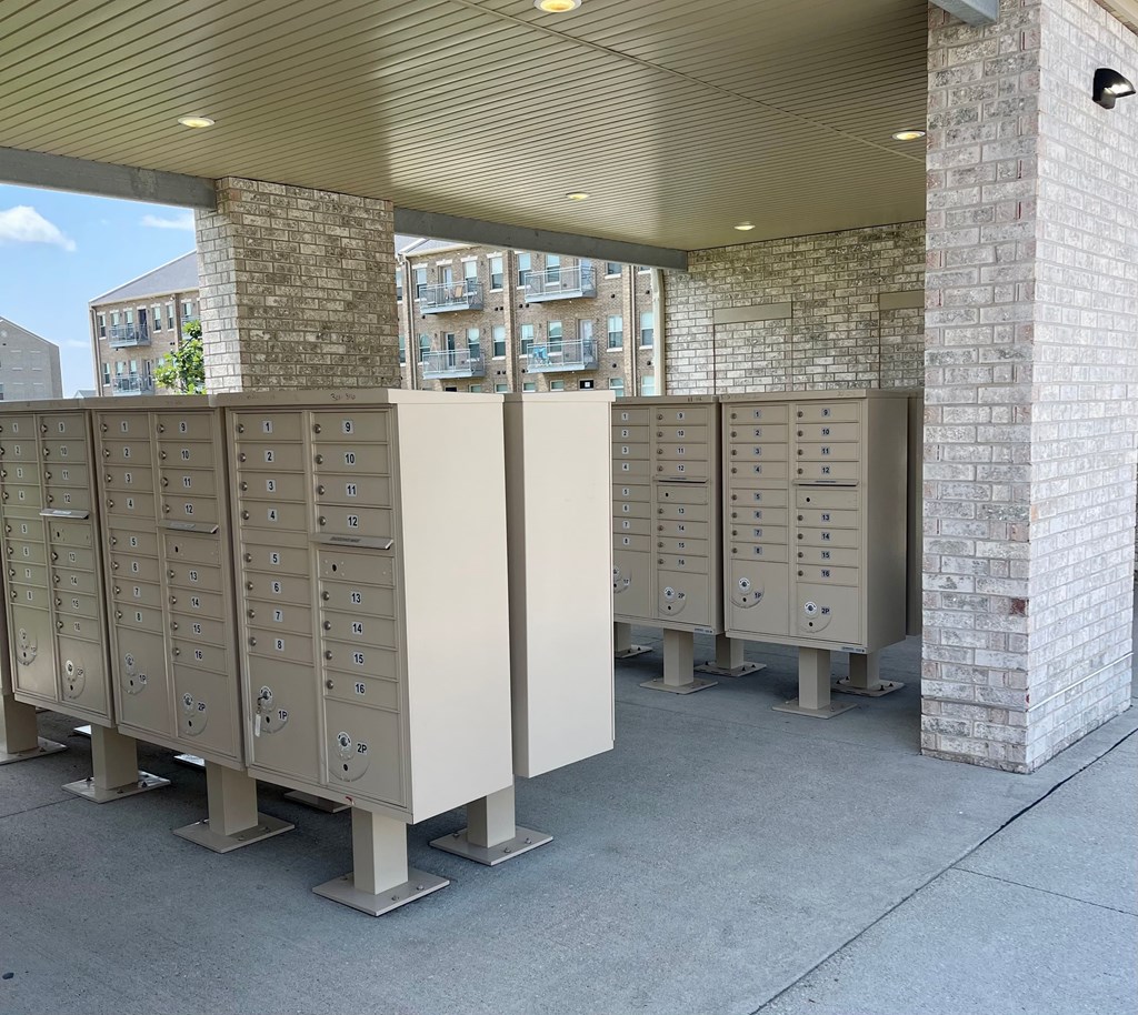 A row of mailboxes are lined up outside a building.