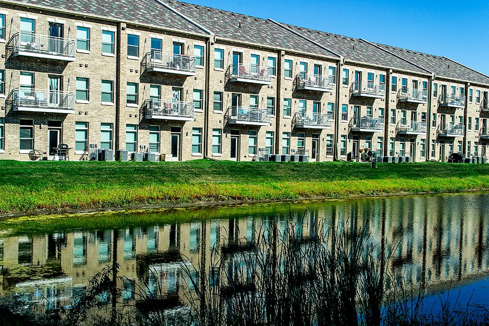 A row of apartment buildings with a body of water in front.