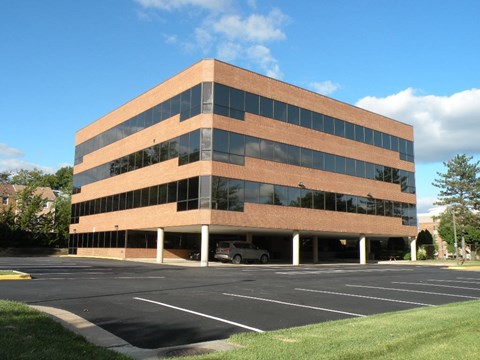 A large office building with a parking lot in front.