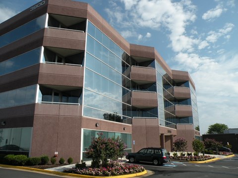 A modern building with a parking lot in front.
