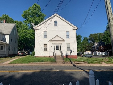 a white house on the corner of a street
