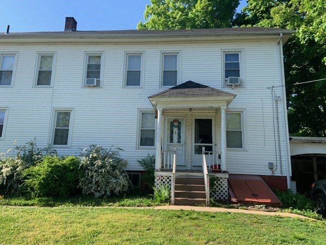 a white house with a yard in front of it