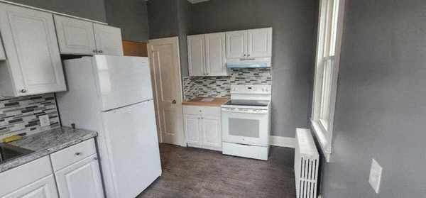 a kitchen with white appliances and white cabinets