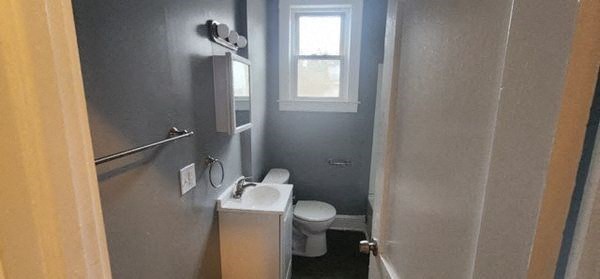 a bathroom with a toilet and a sink and a window