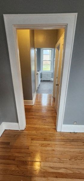 a hallway with a hard wood floor and a window