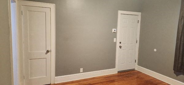 an empty room with a door and a closet