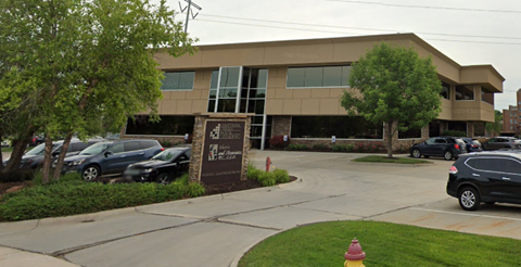 A building with a sign that says "The Woodlands" in front of it.