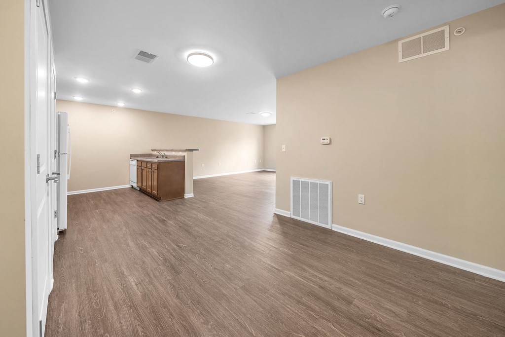 the living room and kitchen of a new home with wood flooring